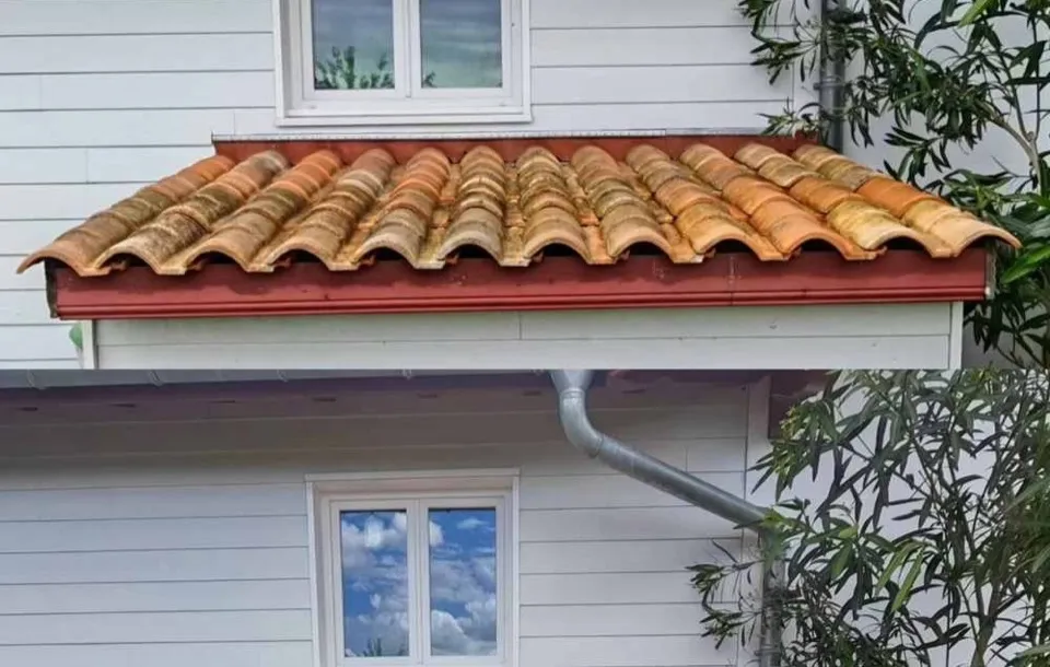 Toiture en tuiles rouges nettoyée à la vapeur dans un quartier résidentiel d'Anglet, sous les pins